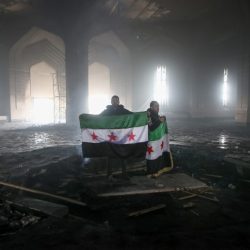 Rebel fighters stand with the flag of the revolution on the burnt gravesite of Syria's late president Hafez al-Assad at his mausoleum in the family's ancestral village of Qardaha in the western Latakia province on December 11, 2024, after it was stormed by opposition factions and set ablaze.,Image: 945450188, License: Rights-managed, Restrictions: , Model Release: no, Credit line: AAREF WATAD / AFP / AFP / Profimedia